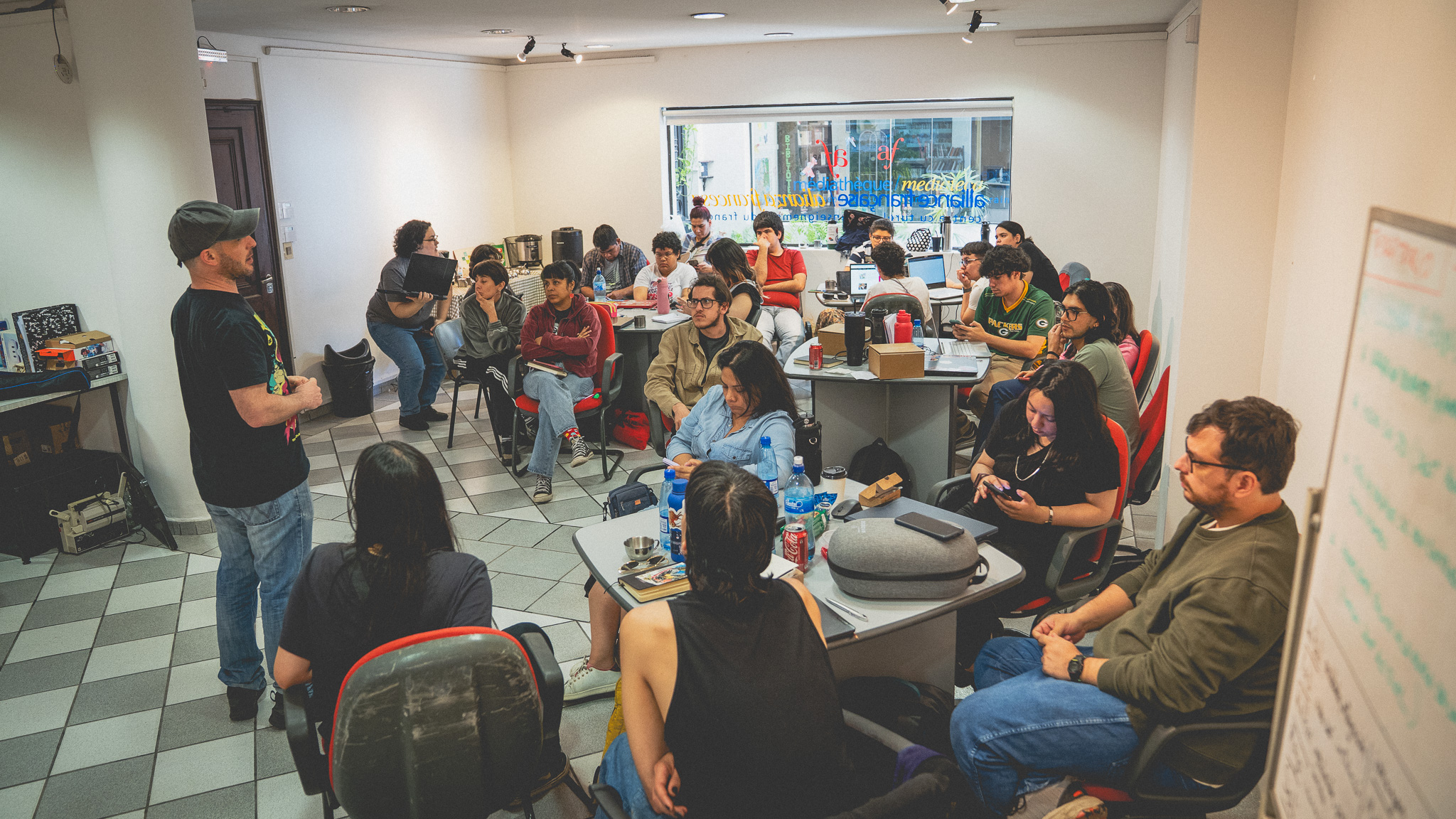 Sesión de taller del EXPYLAB — instructor presenta a participantes reunidos alrededor de mesas en la Alianza Francesa de Asunción
